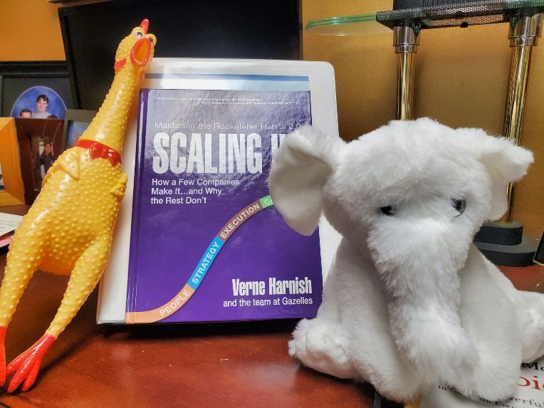 Scaling Up book with rubber chicken and stuffed elephant.